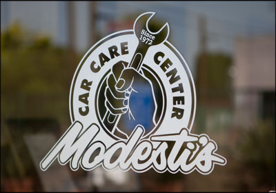 Modesti's Car Care Center Logo Simple On Glass